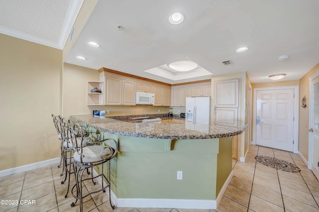 kitchen featuring white appliances, kitchen peninsula, light brown cabinets, light tile patterned floors, and ornamental molding