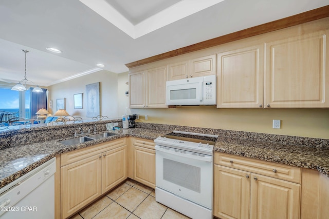 kitchen with white appliances, dark stone countertops, light brown cabinets, and decorative light fixtures