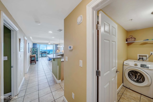 laundry area with light tile patterned flooring and washer / dryer