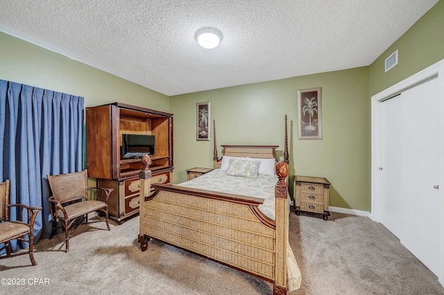 carpeted bedroom with a textured ceiling and a closet