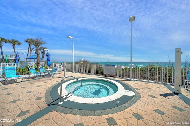 view of swimming pool featuring a water view, a patio area, and a community hot tub