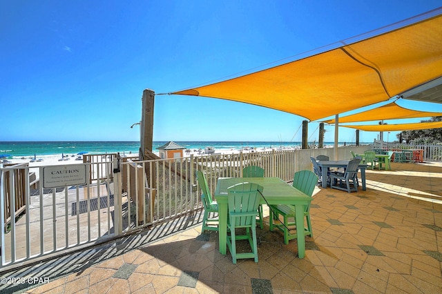 view of patio featuring a beach view and a water view