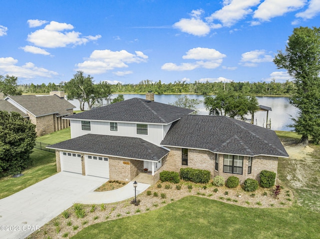 view of front of house with a garage, a water view, and a front yard