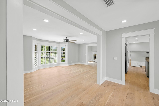 unfurnished living room featuring ceiling fan and light wood-type flooring