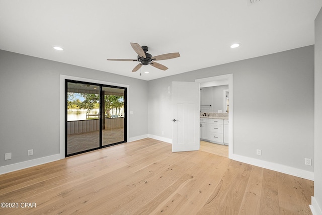 unfurnished bedroom with ceiling fan, connected bathroom, access to outside, and light hardwood / wood-style flooring