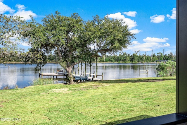 dock area with a lawn and a water view