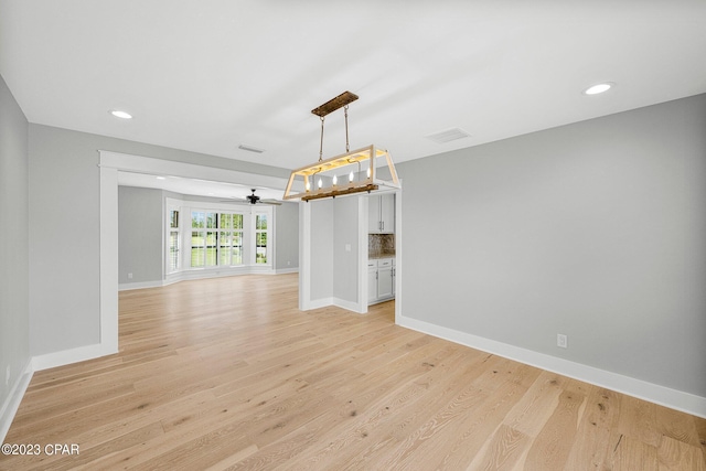 unfurnished dining area featuring ceiling fan and light wood-type flooring