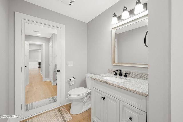 bathroom with vanity, wood-type flooring, and toilet