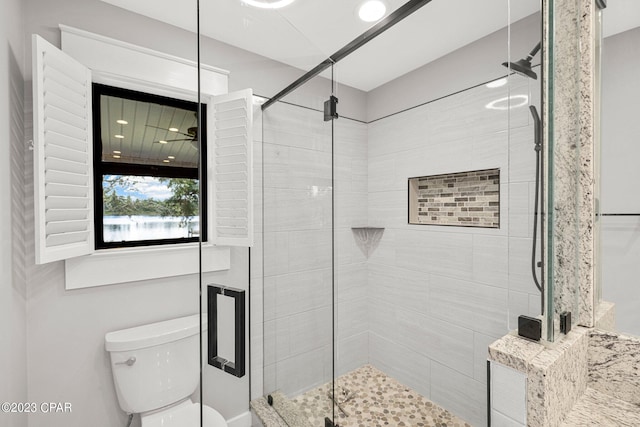 bathroom featuring toilet and an enclosed shower