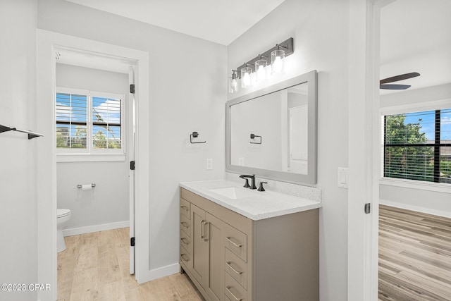 bathroom featuring hardwood / wood-style floors, vanity, toilet, and ceiling fan