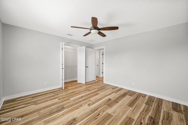 unfurnished bedroom with ceiling fan, a closet, and light wood-type flooring