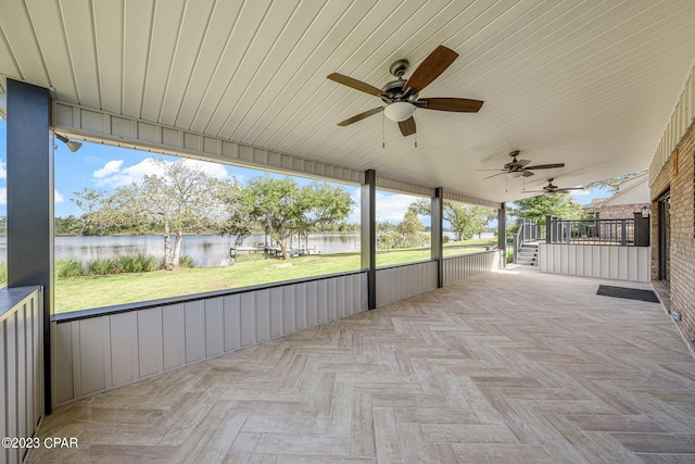 view of patio / terrace with ceiling fan and a water view