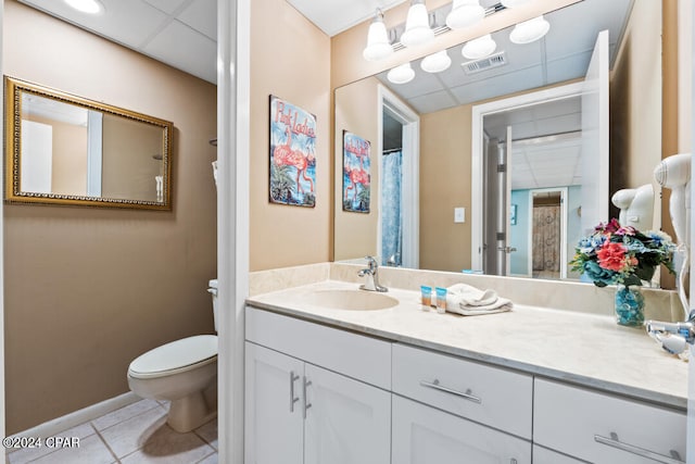 bathroom featuring a paneled ceiling, visible vents, toilet, and tile patterned floors