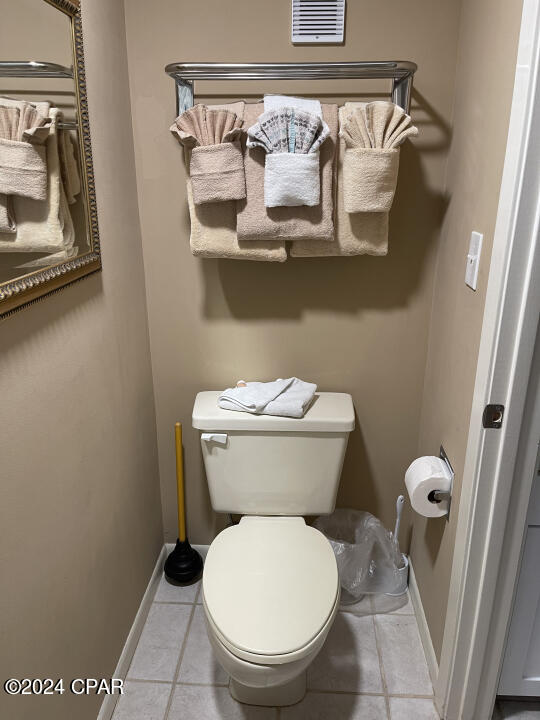 bathroom with baseboards, visible vents, toilet, and tile patterned floors