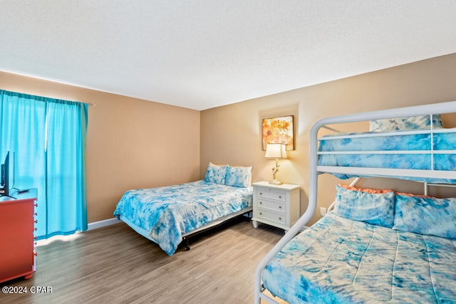 bedroom featuring wood finished floors and baseboards