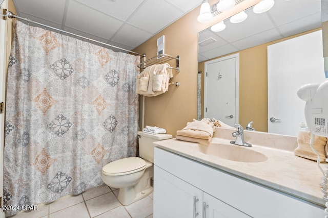 bathroom featuring vanity, a drop ceiling, tile patterned flooring, and toilet