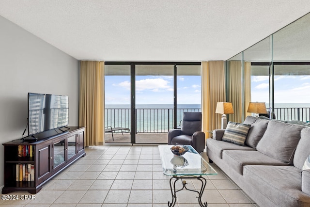 living room featuring expansive windows, light tile patterned floors, a textured ceiling, and plenty of natural light