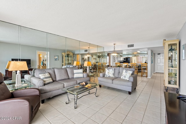 living room featuring light tile patterned floors, visible vents, and a textured ceiling