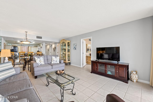 living area with light tile patterned floors, baseboards, and visible vents