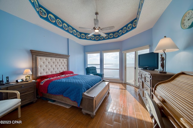 bedroom with hardwood / wood-style flooring, ceiling fan, a textured ceiling, and access to outside