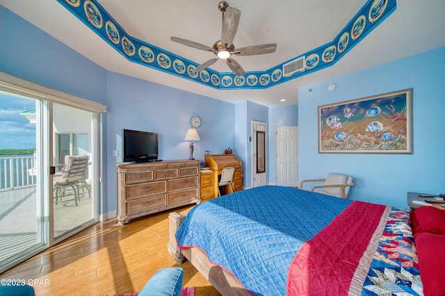 bedroom featuring access to exterior, ceiling fan, wood-type flooring, and a textured ceiling