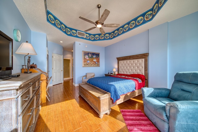 bedroom featuring hardwood / wood-style flooring, ceiling fan, lofted ceiling, and a textured ceiling