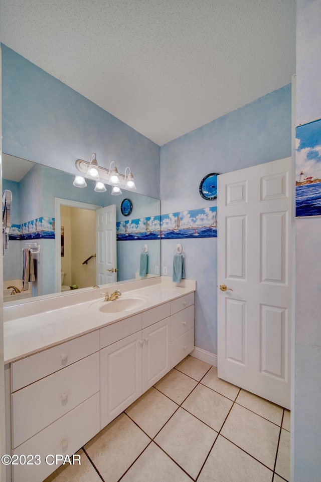 bathroom featuring tile patterned flooring, vanity, and a textured ceiling