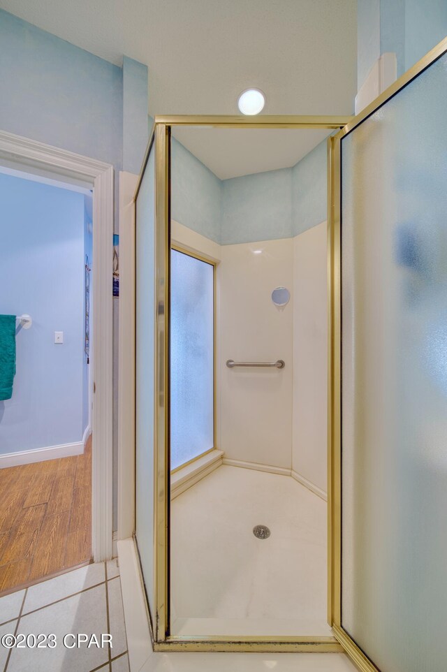 bathroom featuring hardwood / wood-style floors and a shower with door