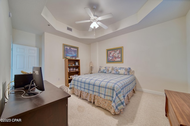 bedroom featuring a tray ceiling, ceiling fan, and light colored carpet