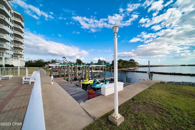 dock area with a water view and a yard