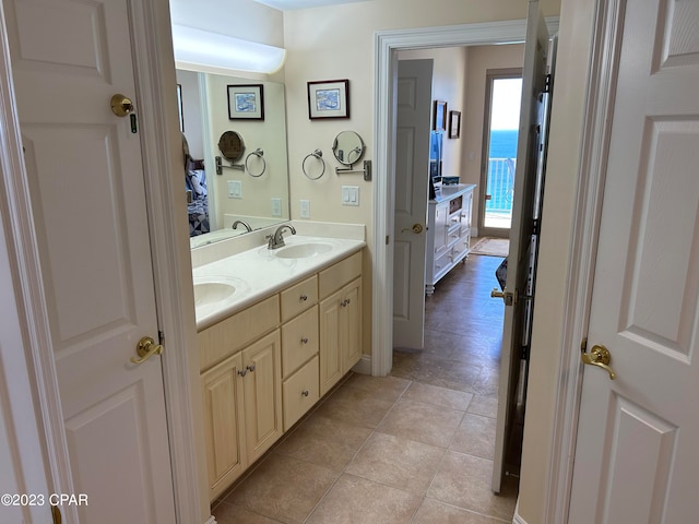 bathroom with tile flooring, dual sinks, vanity with extensive cabinet space, and a water view