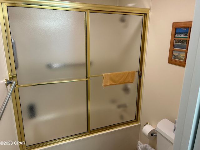 bathroom with enclosed tub / shower combo and toilet