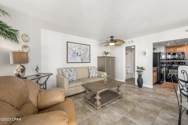 living area with a ceiling fan, visible vents, baseboards, and light tile patterned flooring