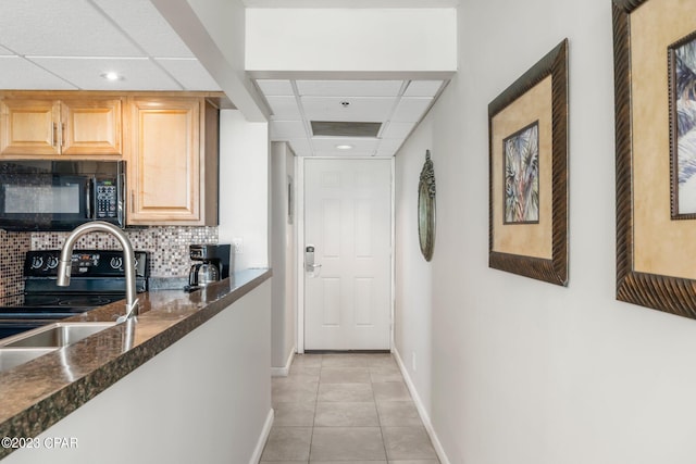 interior space with sink, a paneled ceiling, and light tile patterned floors