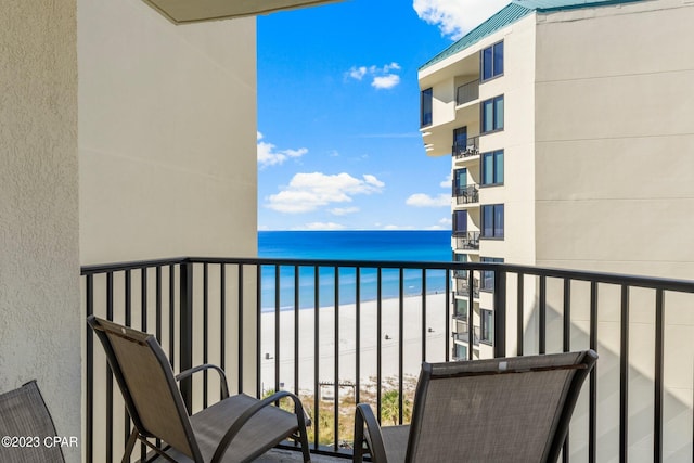 balcony with a water view and a beach view