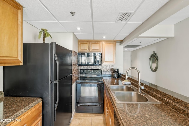 kitchen featuring light tile patterned floors, a sink, visible vents, black appliances, and tasteful backsplash