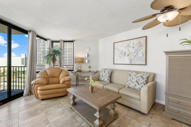 living room featuring a wall of windows, ceiling fan, baseboards, and light tile patterned floors