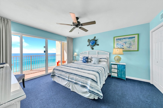 bedroom with ceiling fan, access to outside, a closet, a water view, and dark carpet