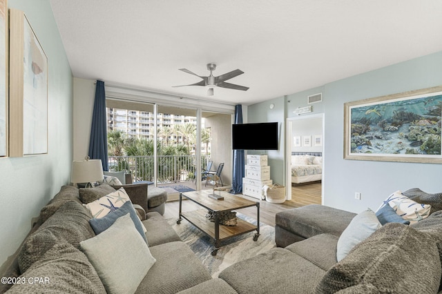 living room with ceiling fan, floor to ceiling windows, and wood-type flooring