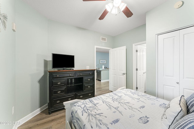 bedroom with dark hardwood / wood-style flooring, a closet, and ceiling fan