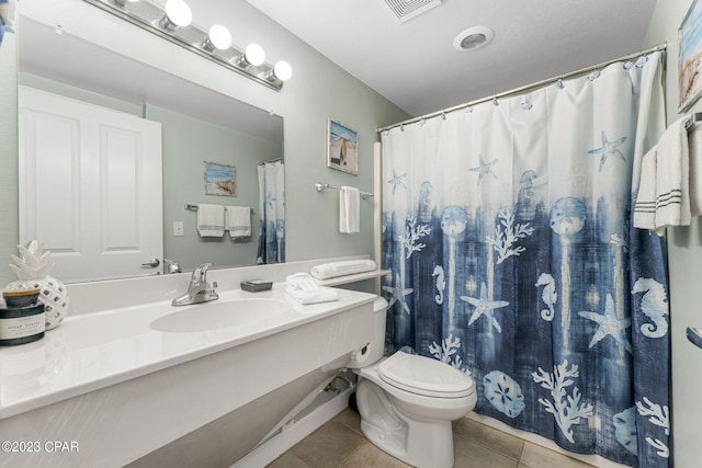 bathroom with toilet, a shower with curtain, vanity, and tile patterned floors