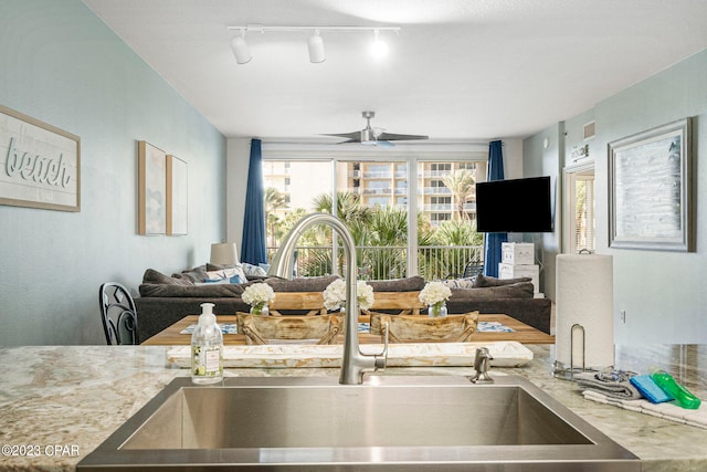 kitchen featuring rail lighting, ceiling fan, and sink