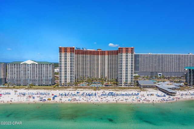 view of building exterior with a beach view and a water view