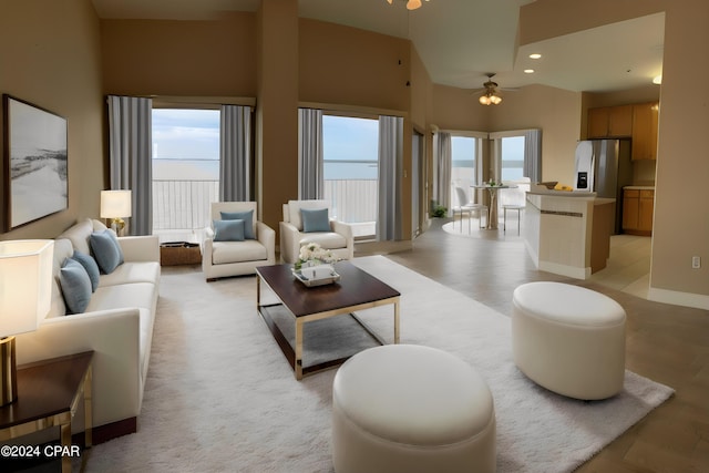 living room featuring ceiling fan and a high ceiling