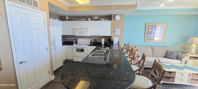 kitchen with dark hardwood / wood-style floors, white appliances, sink, ornamental molding, and white cabinetry