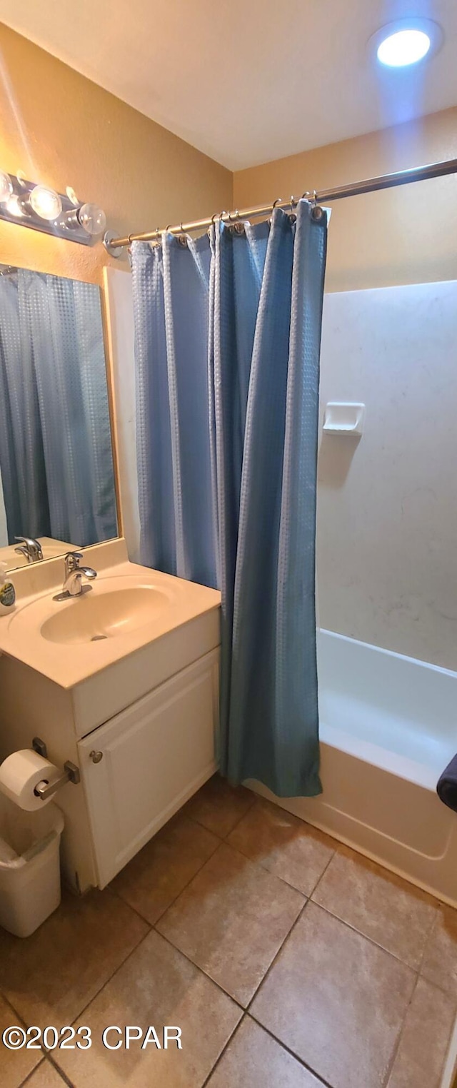 bathroom with shower / tub combo with curtain, large vanity, and tile flooring