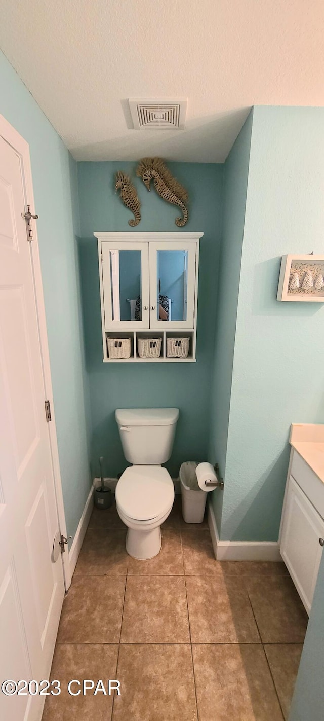 bathroom featuring vanity, tile flooring, and toilet