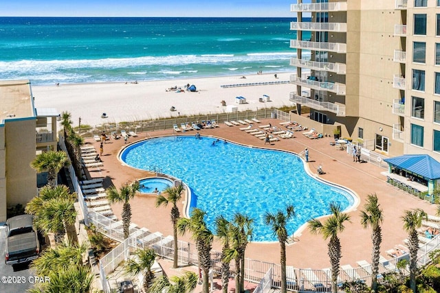 view of pool featuring a beach view and a water view