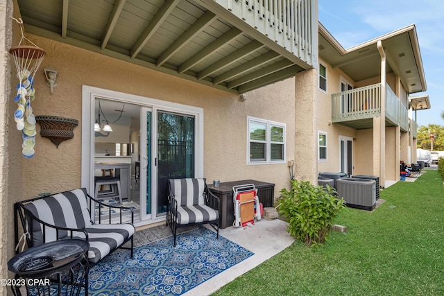 exterior space with a balcony, a patio area, a lawn, and central air condition unit