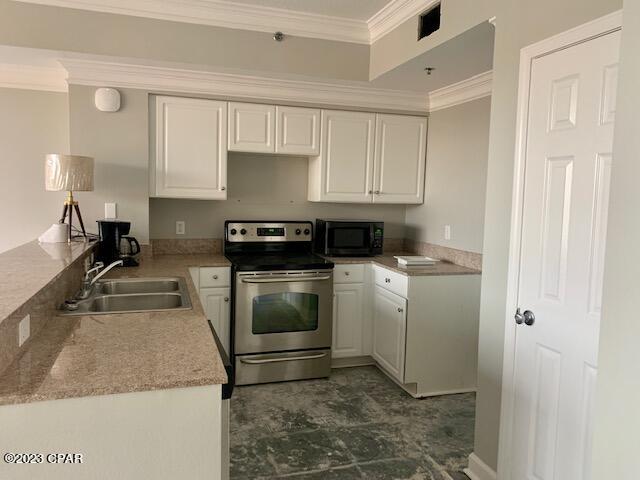 kitchen featuring electric stove, white cabinets, dark tile floors, and sink